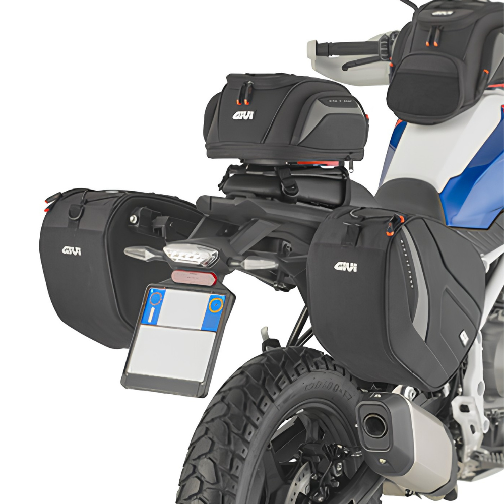 Black Givi motorcycle luggage set including side bags, a top box, and a rear rack bag, shown on a white and blue motorcycle against a white background.