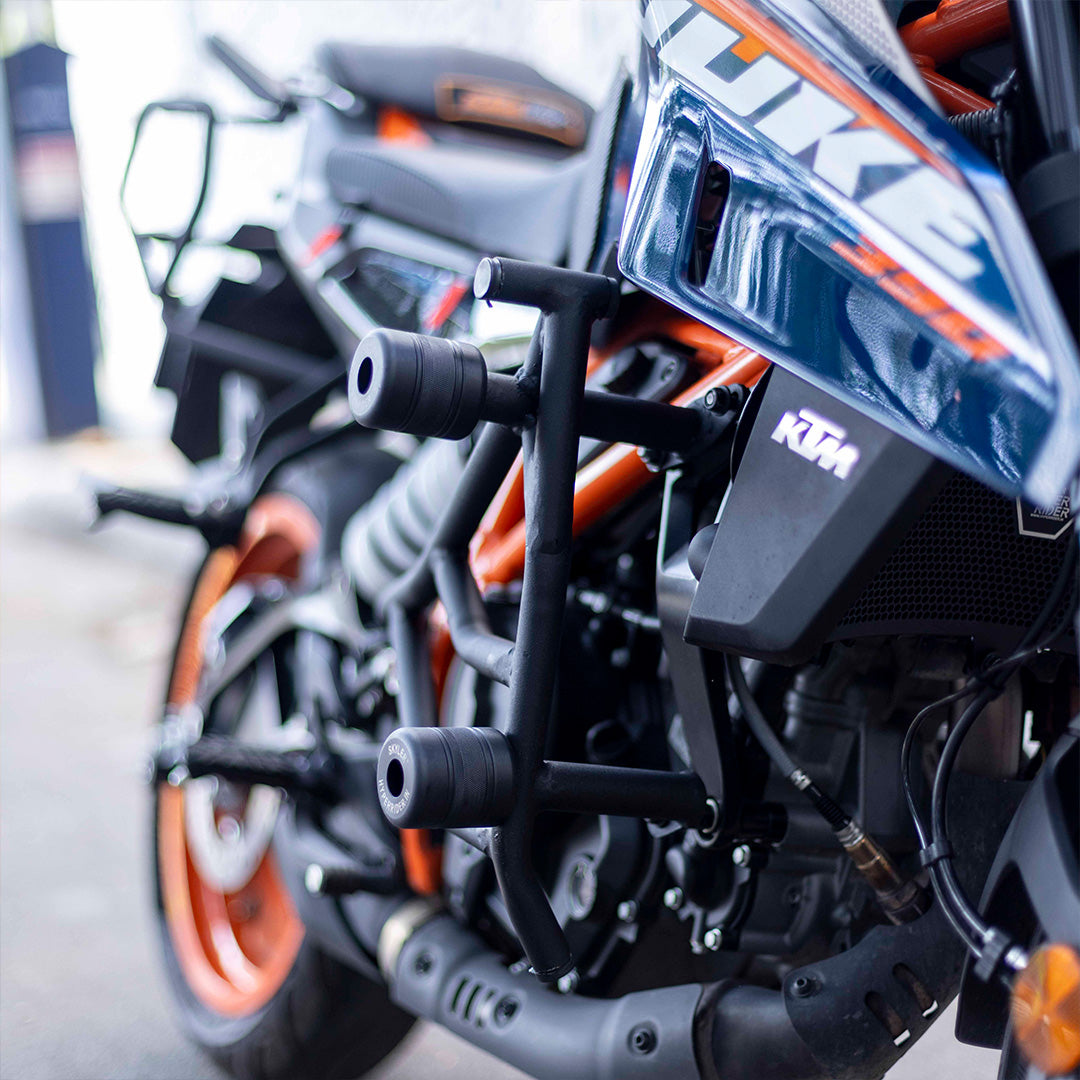Close-up of a KTM motorcycle with focus on the front headlight and handlebars.