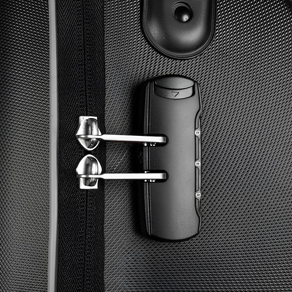 Close-up of a black luggage lock with silver metal tumblers and dials, mounted on a textured black suitcase shell.