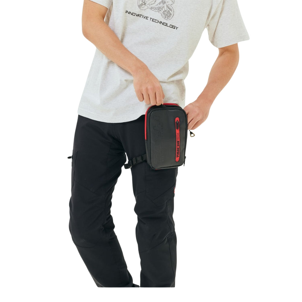 Person holding a black and red bag on a white background