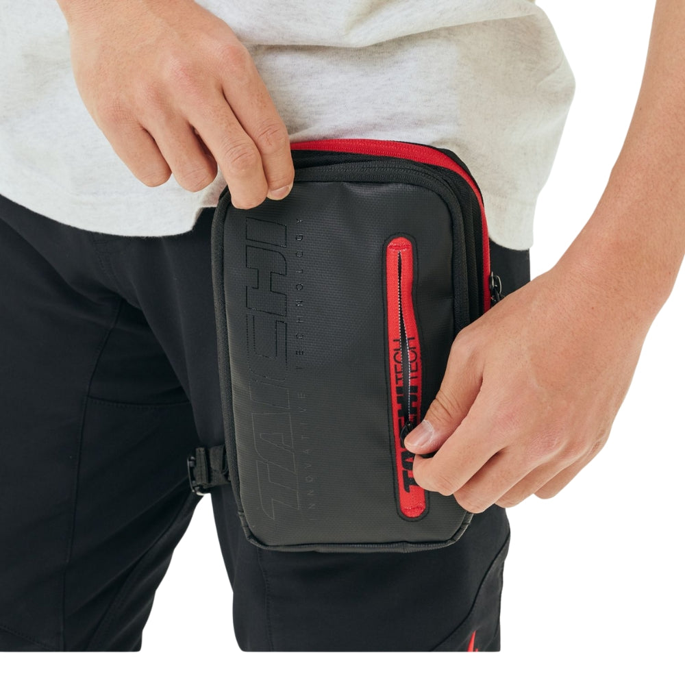 Person holding a black and red bag with visible branding