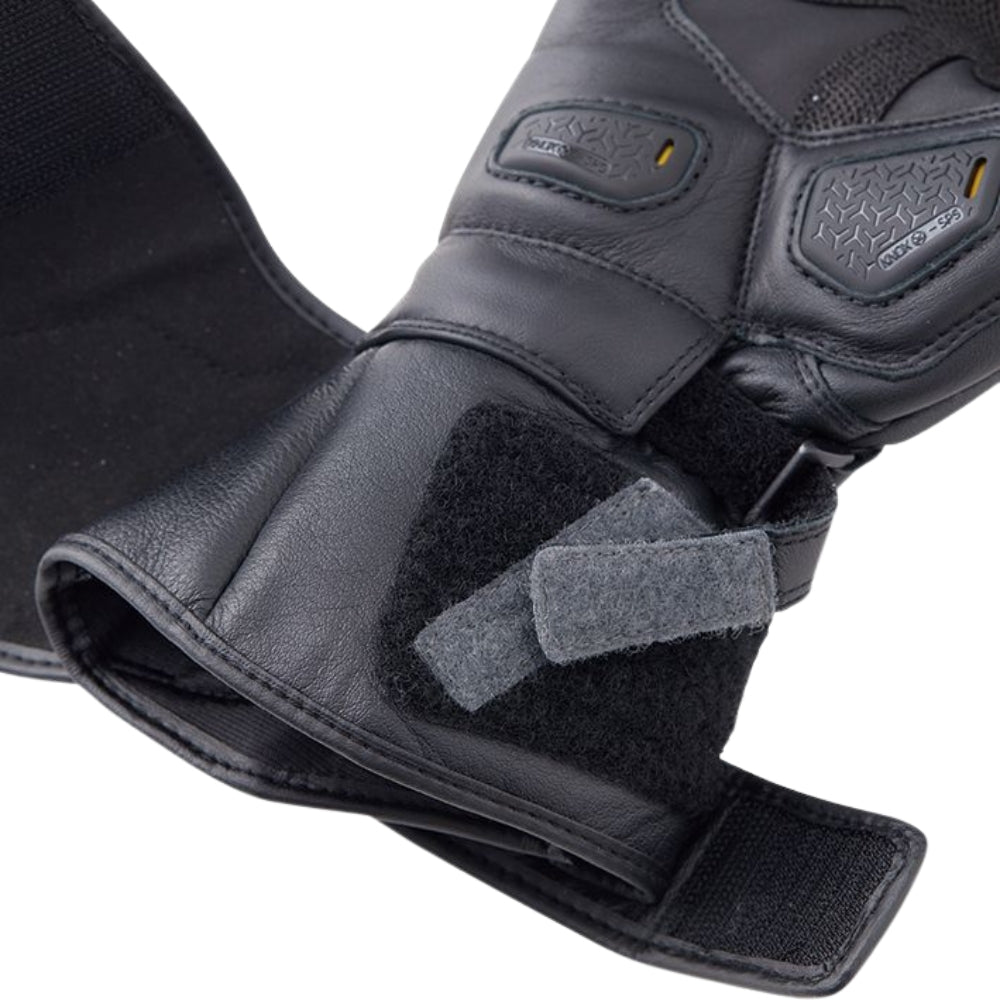 Close-up of a black protective glove with padding and velcro straps on a white background
